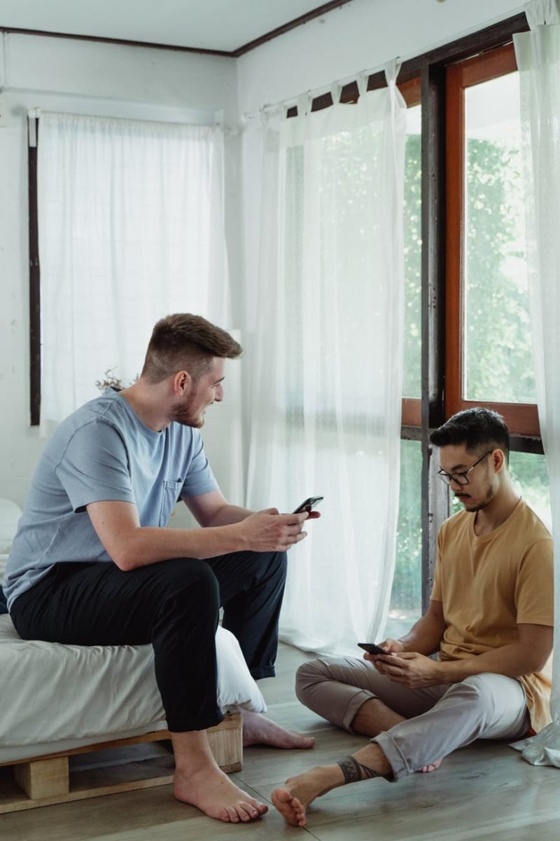 men holding cellphone while having a conversation