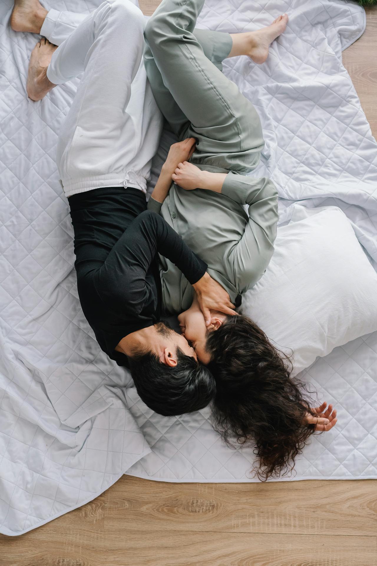 Polyamorous couple sitting together laughing, symbolizing trust and openness